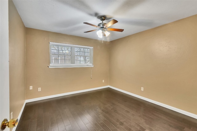 unfurnished room featuring dark wood-type flooring and ceiling fan