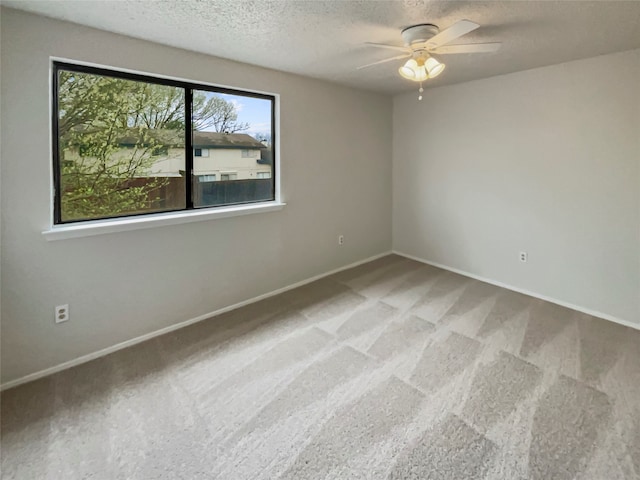 carpeted spare room with a textured ceiling and ceiling fan