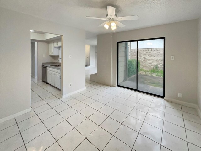 tiled spare room featuring sink, a textured ceiling, and ceiling fan