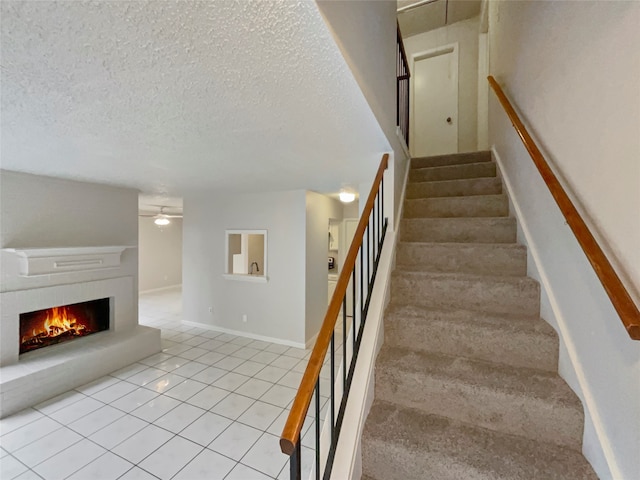 stairs with a textured ceiling and light tile patterned floors