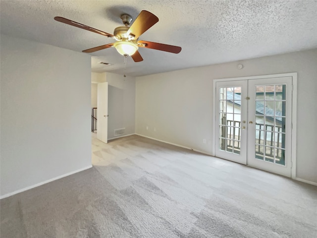 carpeted empty room featuring french doors, ceiling fan, and a textured ceiling