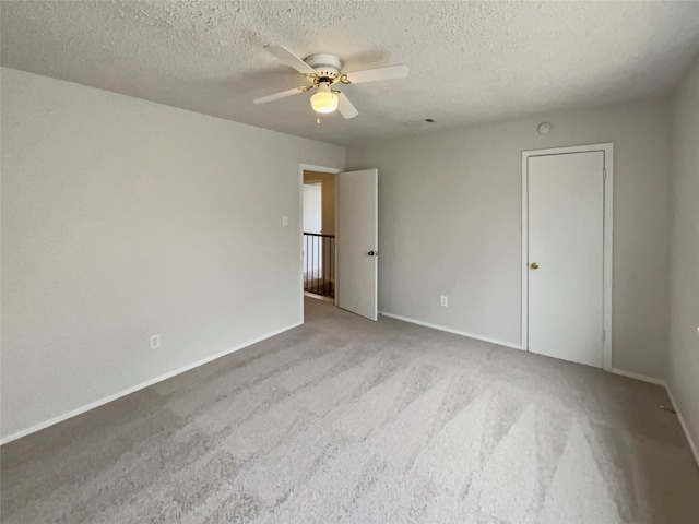 unfurnished bedroom with carpet floors, a textured ceiling, and ceiling fan