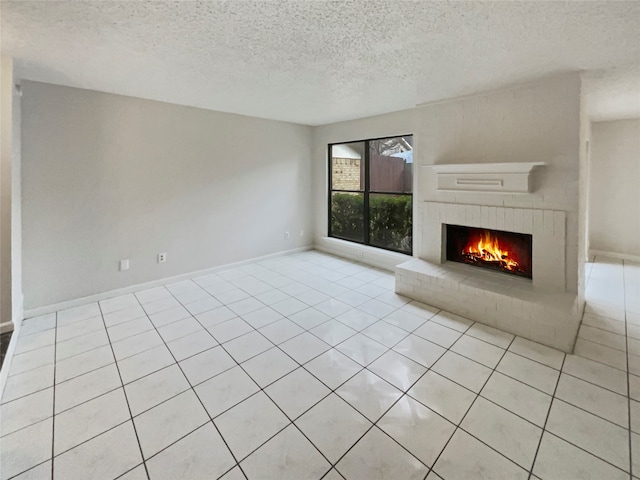 unfurnished living room featuring a textured ceiling, a brick fireplace, and light tile patterned floors