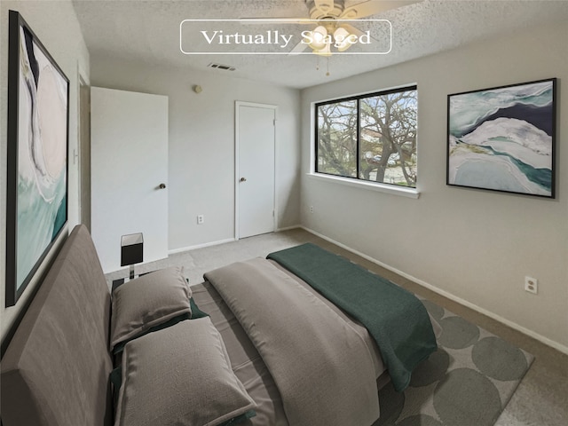 carpeted bedroom with a textured ceiling and ceiling fan