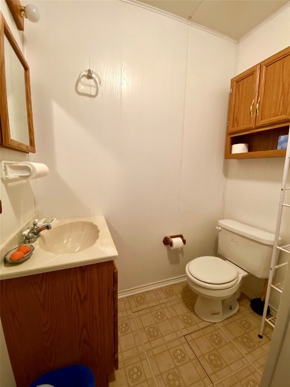 bathroom with crown molding, toilet, tile floors, and vanity with extensive cabinet space