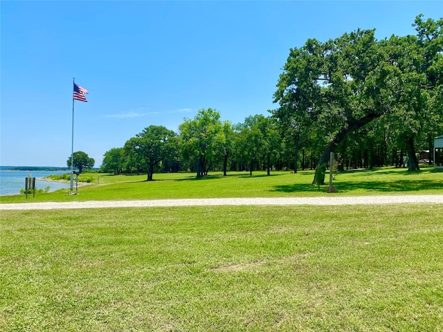 surrounding community featuring a water view and a lawn