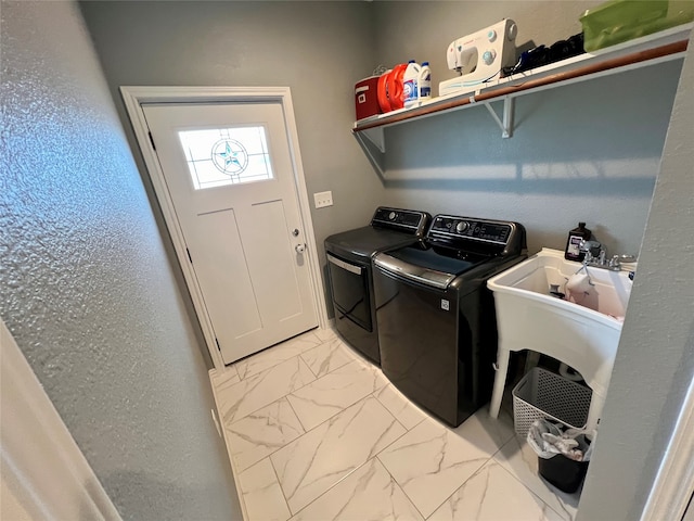 clothes washing area featuring separate washer and dryer and sink