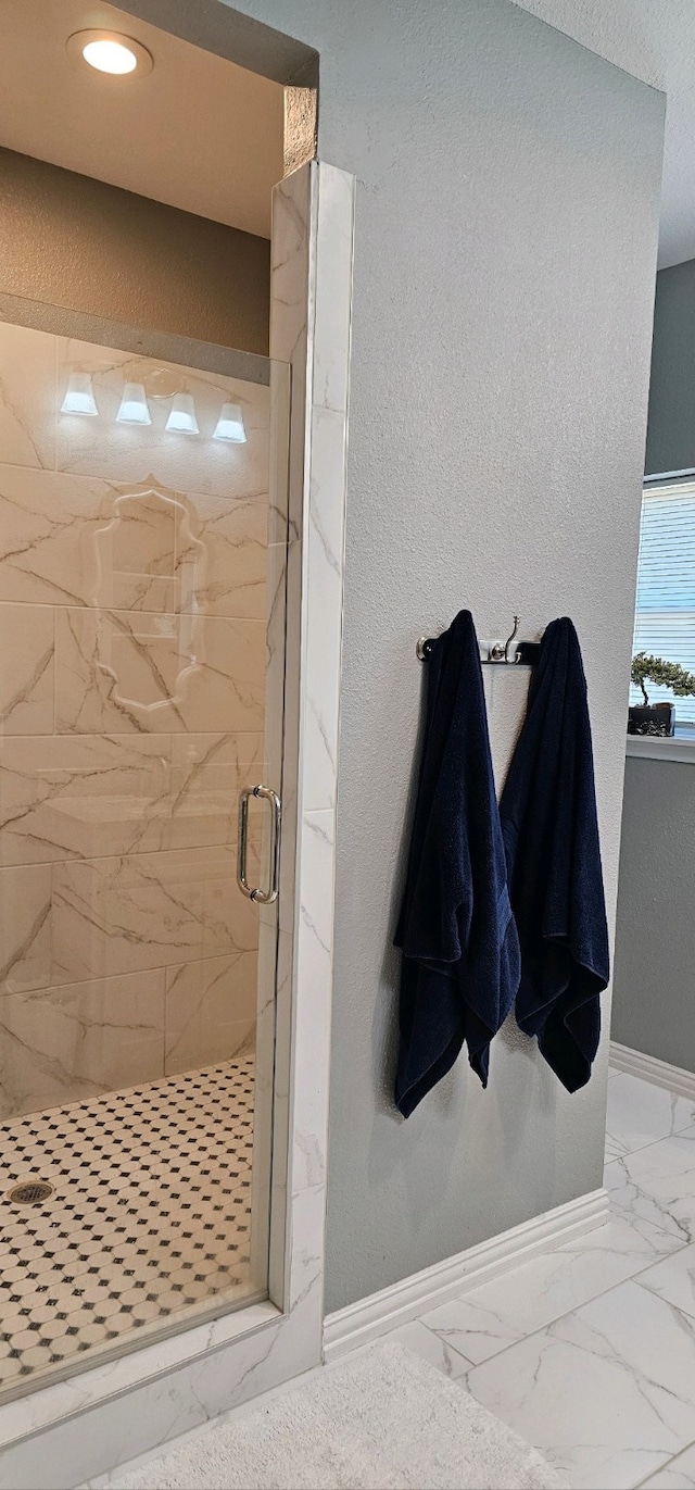 bathroom with a shower with door