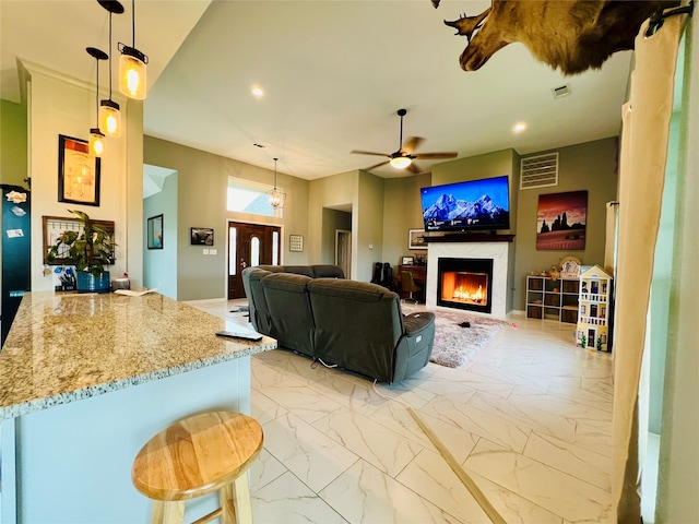 living room featuring ceiling fan and a fireplace