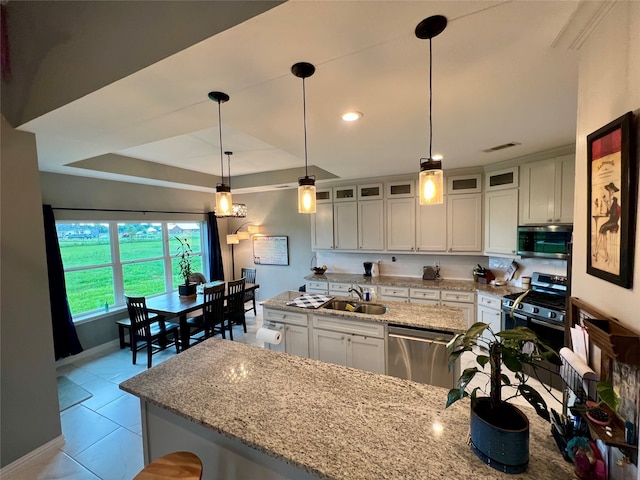 kitchen featuring appliances with stainless steel finishes, light tile patterned floors, white cabinets, and pendant lighting