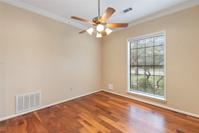 empty room with a wealth of natural light, ceiling fan, hardwood / wood-style flooring, and ornamental molding