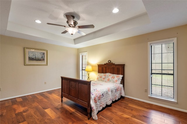 bedroom with multiple windows and a tray ceiling