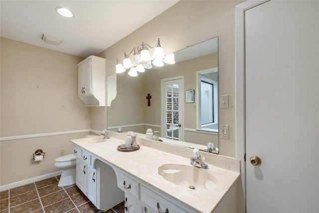 bathroom featuring toilet, tile floors, and dual bowl vanity