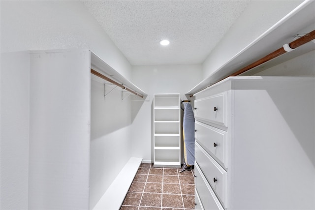 spacious closet featuring dark tile floors