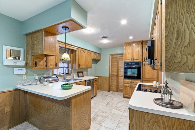 kitchen with light tile flooring, kitchen peninsula, black appliances, hanging light fixtures, and sink