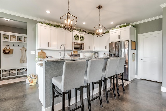 kitchen featuring a fireplace, ceiling fan with notable chandelier, a center island with sink, tasteful backsplash, and white cabinetry