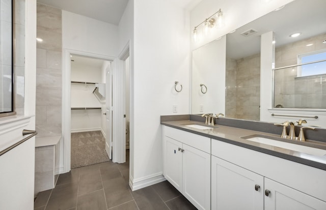 bathroom featuring tile patterned floors, vanity, and a shower with shower door