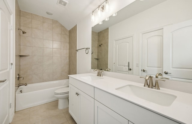 full bathroom with vanity, tiled shower / bath combo, tile patterned flooring, toilet, and lofted ceiling