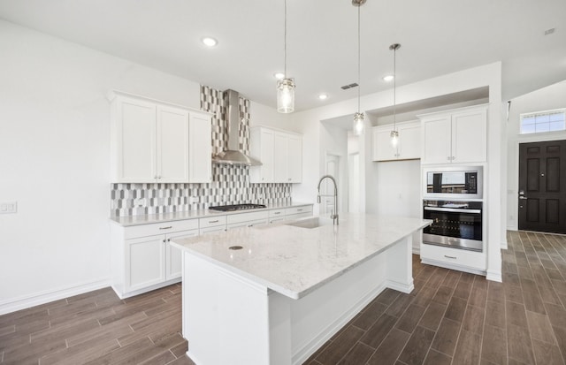 kitchen featuring pendant lighting, white cabinets, sink, an island with sink, and stainless steel appliances