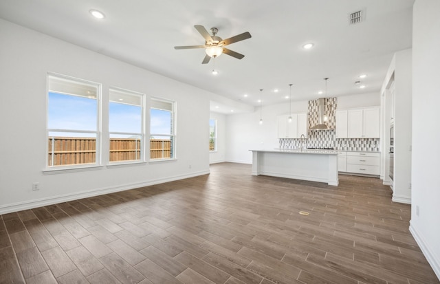 unfurnished living room with dark hardwood / wood-style floors and ceiling fan