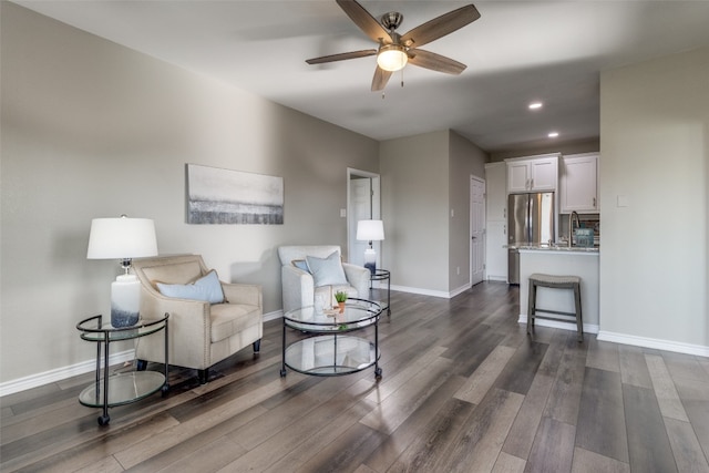 living room featuring dark hardwood / wood-style floors, ceiling fan, and sink