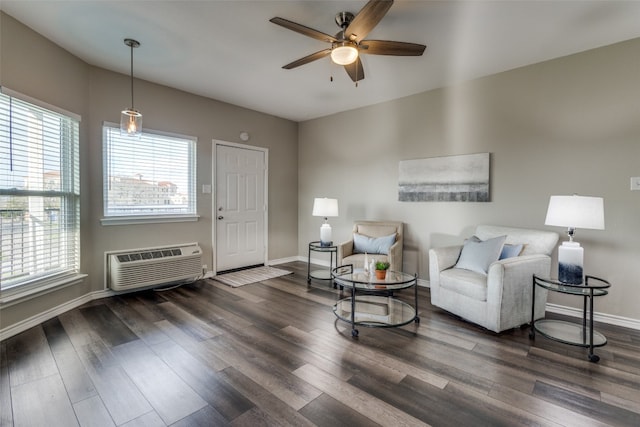 living room with a wall mounted AC, dark hardwood / wood-style flooring, and ceiling fan