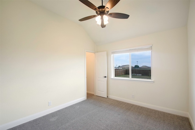 empty room featuring ceiling fan, light colored carpet, and vaulted ceiling