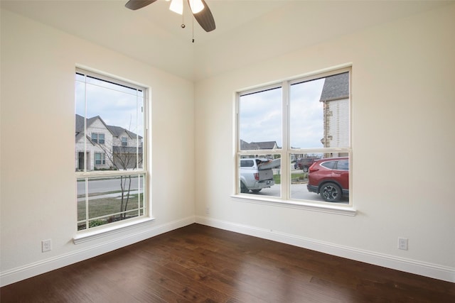 empty room with ceiling fan and dark wood-type flooring