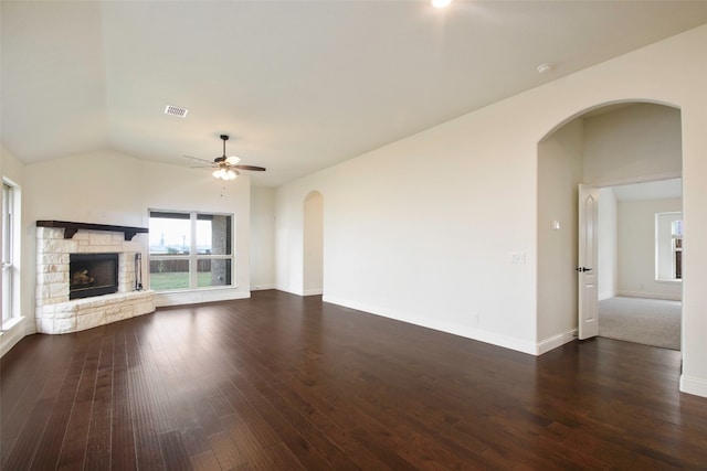 unfurnished living room with dark hardwood / wood-style floors, vaulted ceiling, a fireplace, and ceiling fan