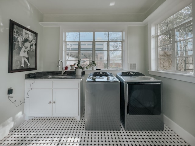 laundry room with separate washer and dryer, a wealth of natural light, cabinets, and sink