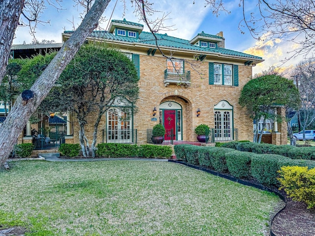 view of front of property featuring french doors and a lawn