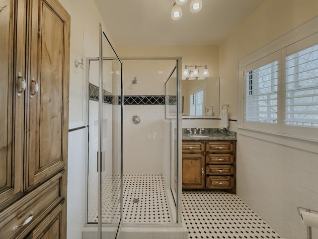 bathroom with tile flooring, vanity, and an enclosed shower