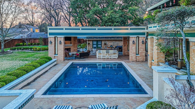 view of pool with a fireplace, a lawn, and a patio