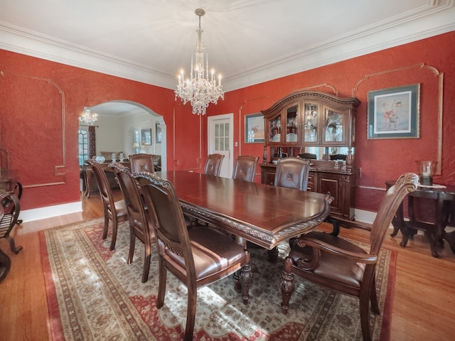 dining space featuring ornamental molding, a chandelier, and light wood-type flooring