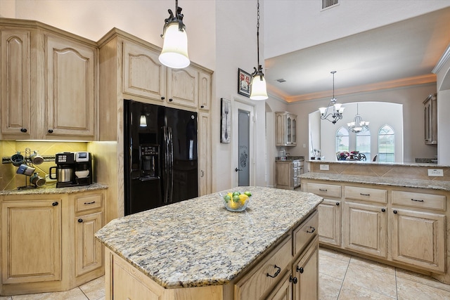 kitchen featuring black fridge, an inviting chandelier, a kitchen island, and hanging light fixtures