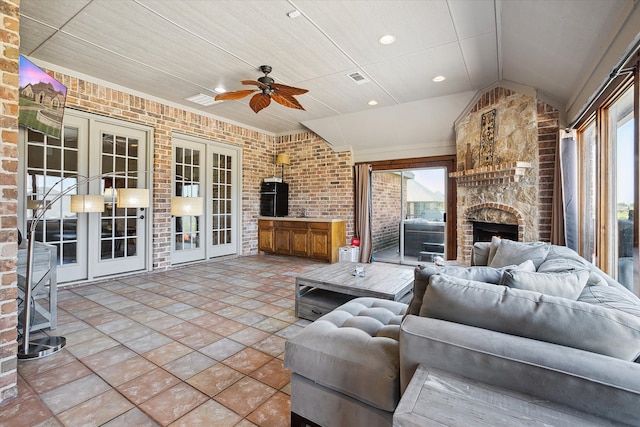 living room with ceiling fan, a fireplace, wood ceiling, french doors, and brick wall