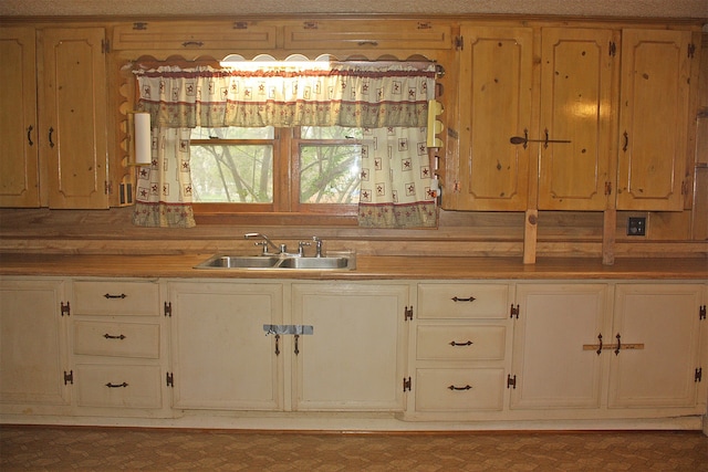 kitchen featuring a textured ceiling and sink