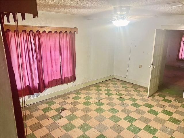 unfurnished room featuring a textured ceiling and ceiling fan