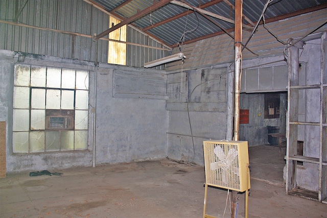 interior space with concrete floors, high vaulted ceiling, and heating unit