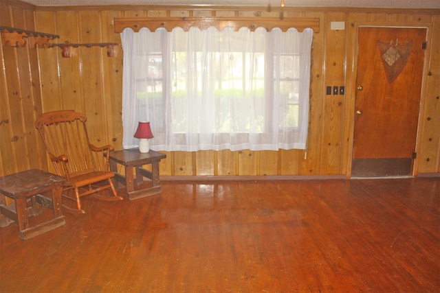 interior space with hardwood / wood-style flooring and wood walls