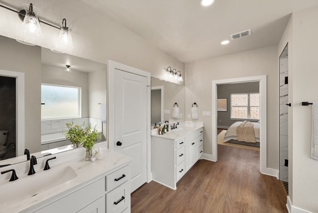 bathroom with toilet, vanity, and hardwood / wood-style floors