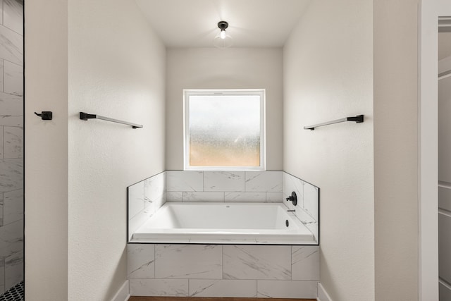 bathroom featuring a relaxing tiled tub