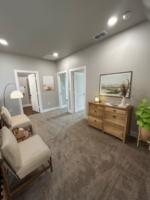 sitting room featuring dark colored carpet