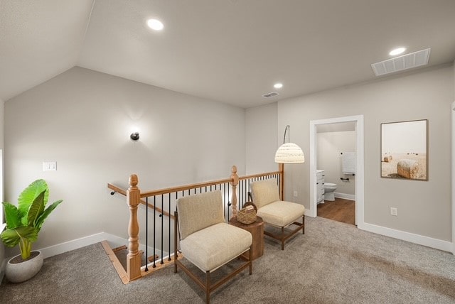 sitting room with lofted ceiling and carpet floors