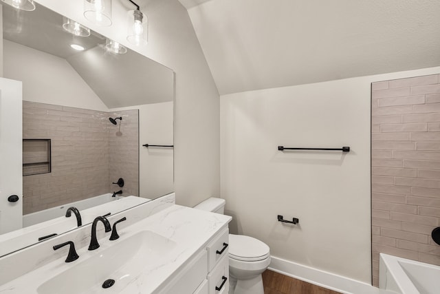 full bathroom with hardwood / wood-style floors, tiled shower / bath, toilet, and vaulted ceiling