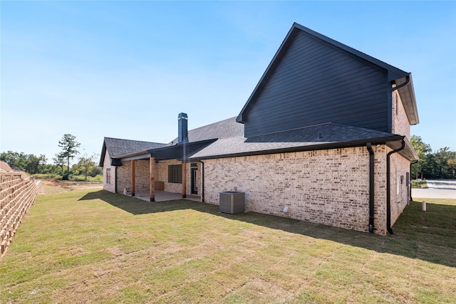 rear view of house featuring central AC unit, a patio, and a yard