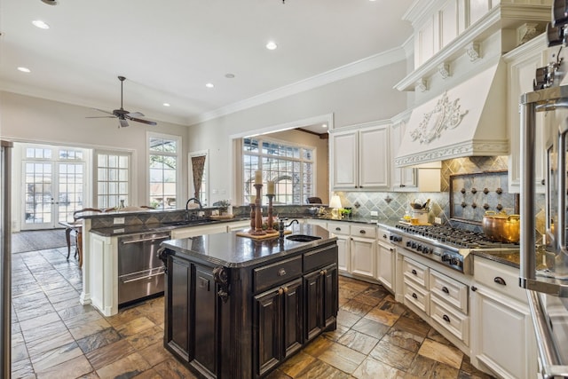 kitchen with backsplash, ceiling fan, tile flooring, a center island, and appliances with stainless steel finishes