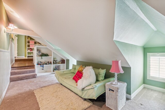 carpeted living room with lofted ceiling and built in shelves