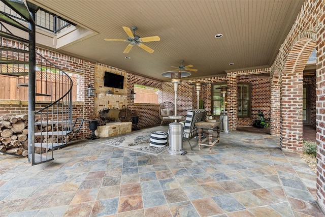 view of patio featuring an outdoor brick fireplace and ceiling fan