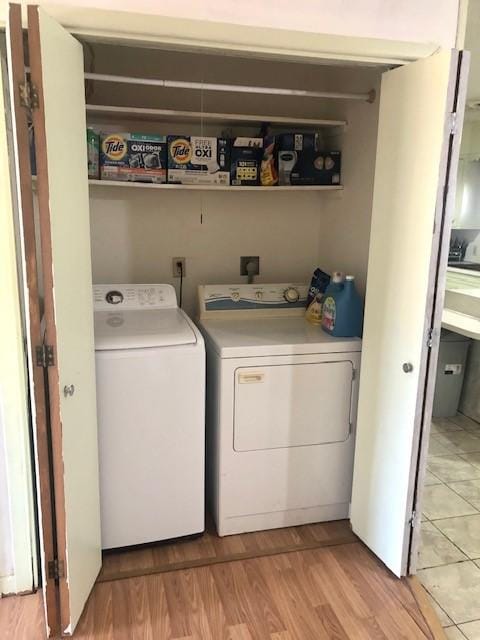 washroom featuring washing machine and clothes dryer and light wood-type flooring